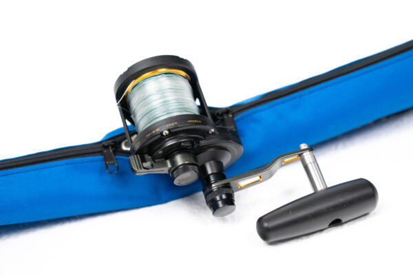 A fishing reel sitting on top of a blue sleeve.